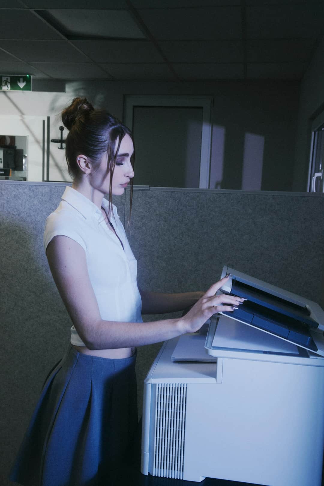 Professional woman retrieving documents from office copier in finance workplace