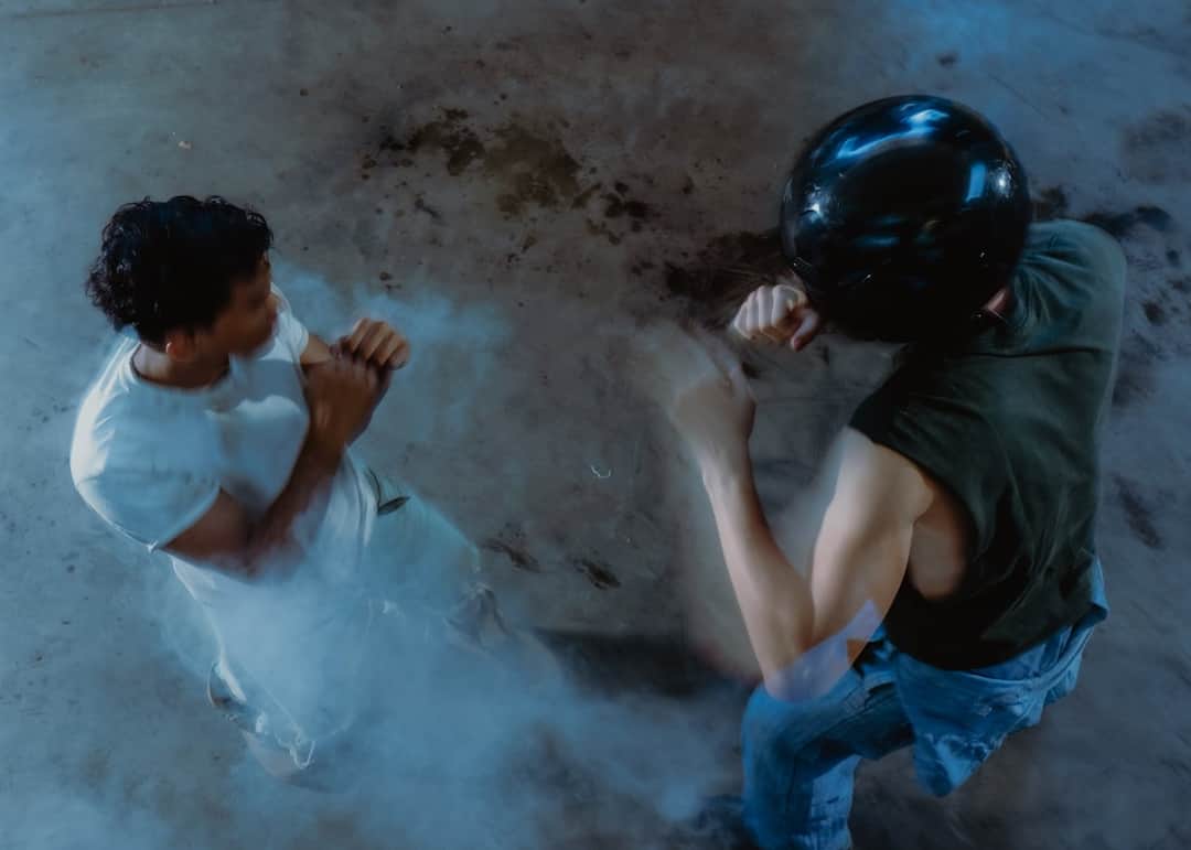 Two fighters competing in overhead boxing match with blue smoke effect