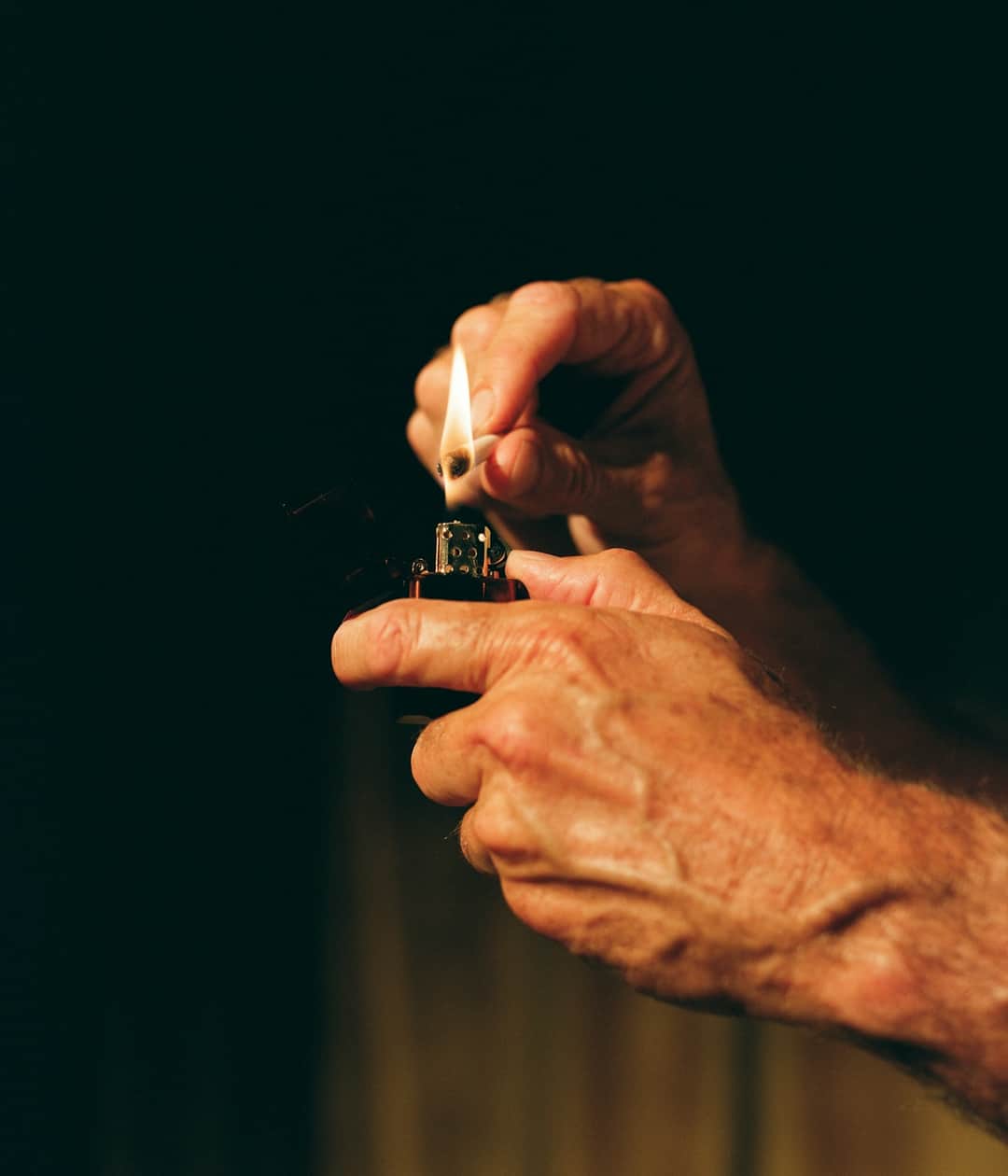 Hands holding lit lighter for nicotine industry analysis