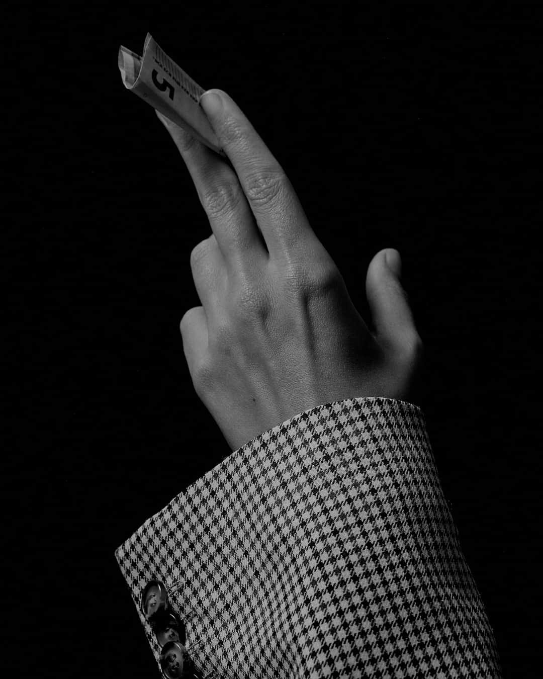 Hand holding banknote representing paid media investment and marketing budget