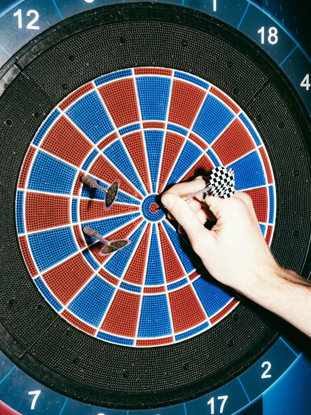 Dart hitting target on numbered dartboard