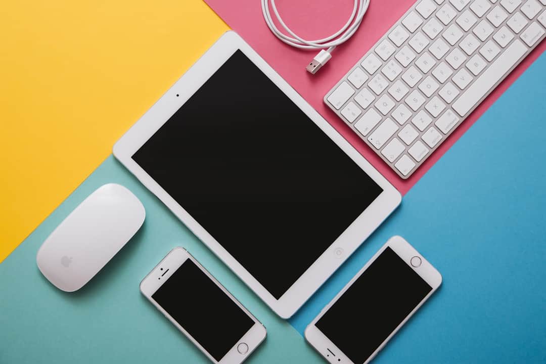 White tablet, smartphones, keyboard and mouse on colorful background for digital marketing