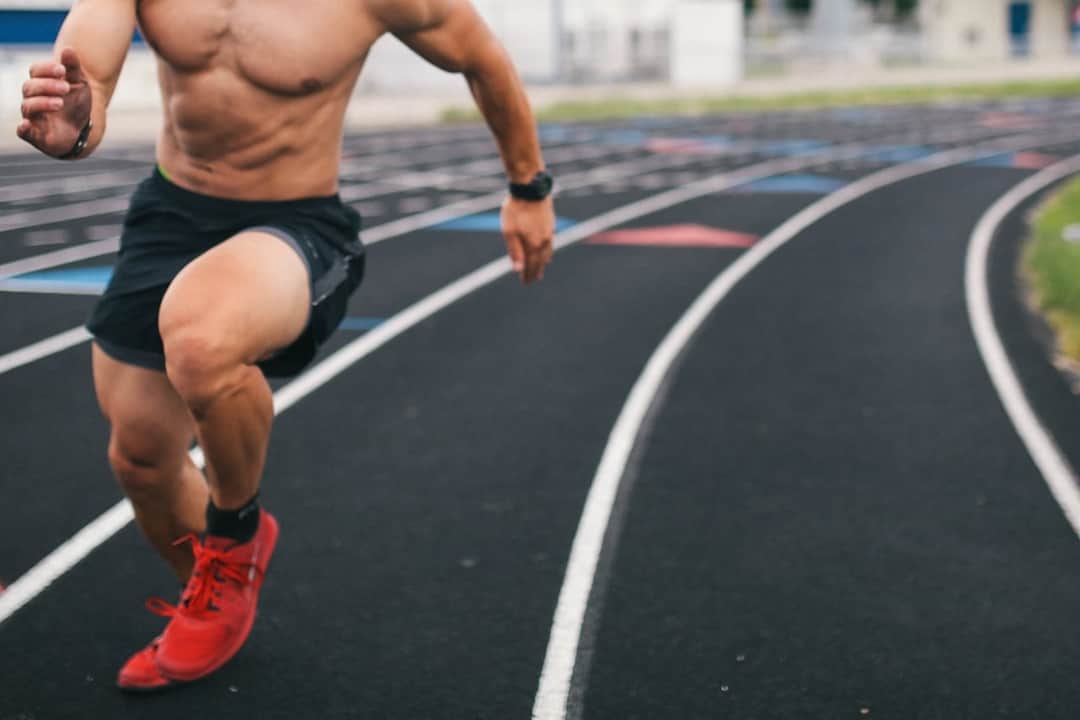 Athlete sprinting on outdoor track wearing red running shoes
