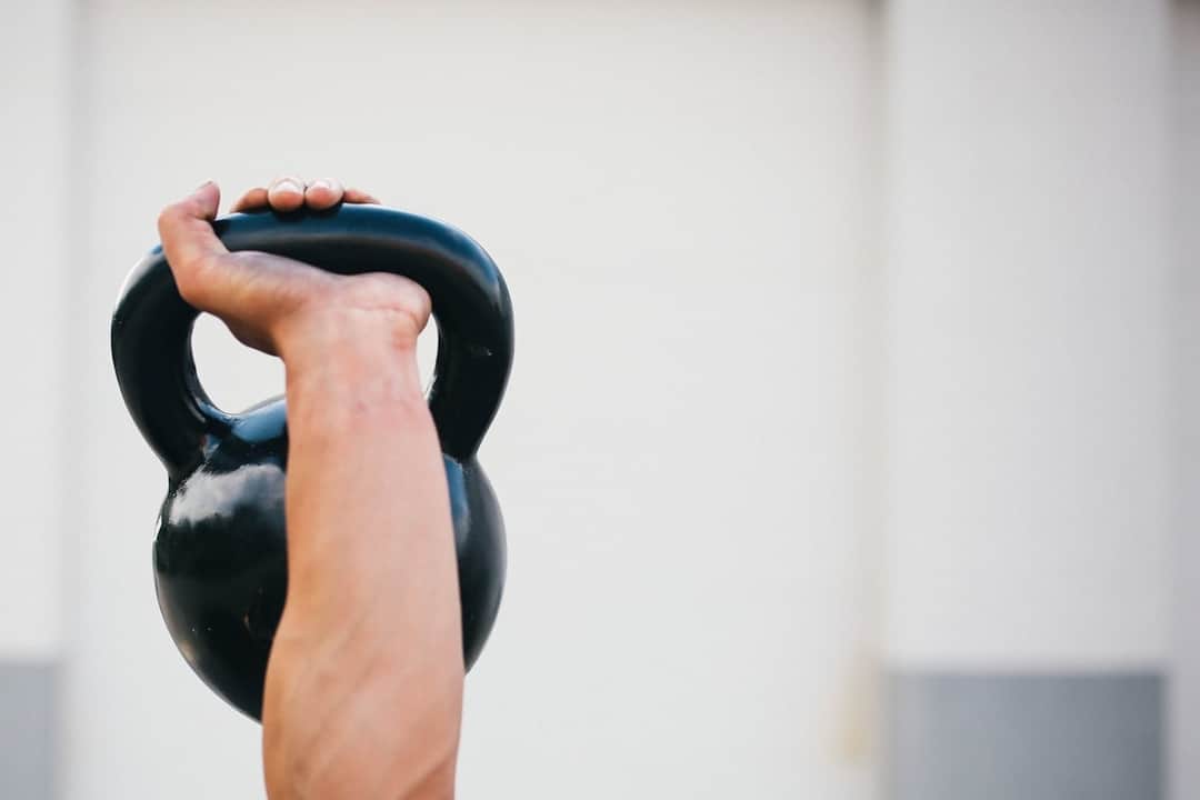 Person holding black kettlebell during strength training