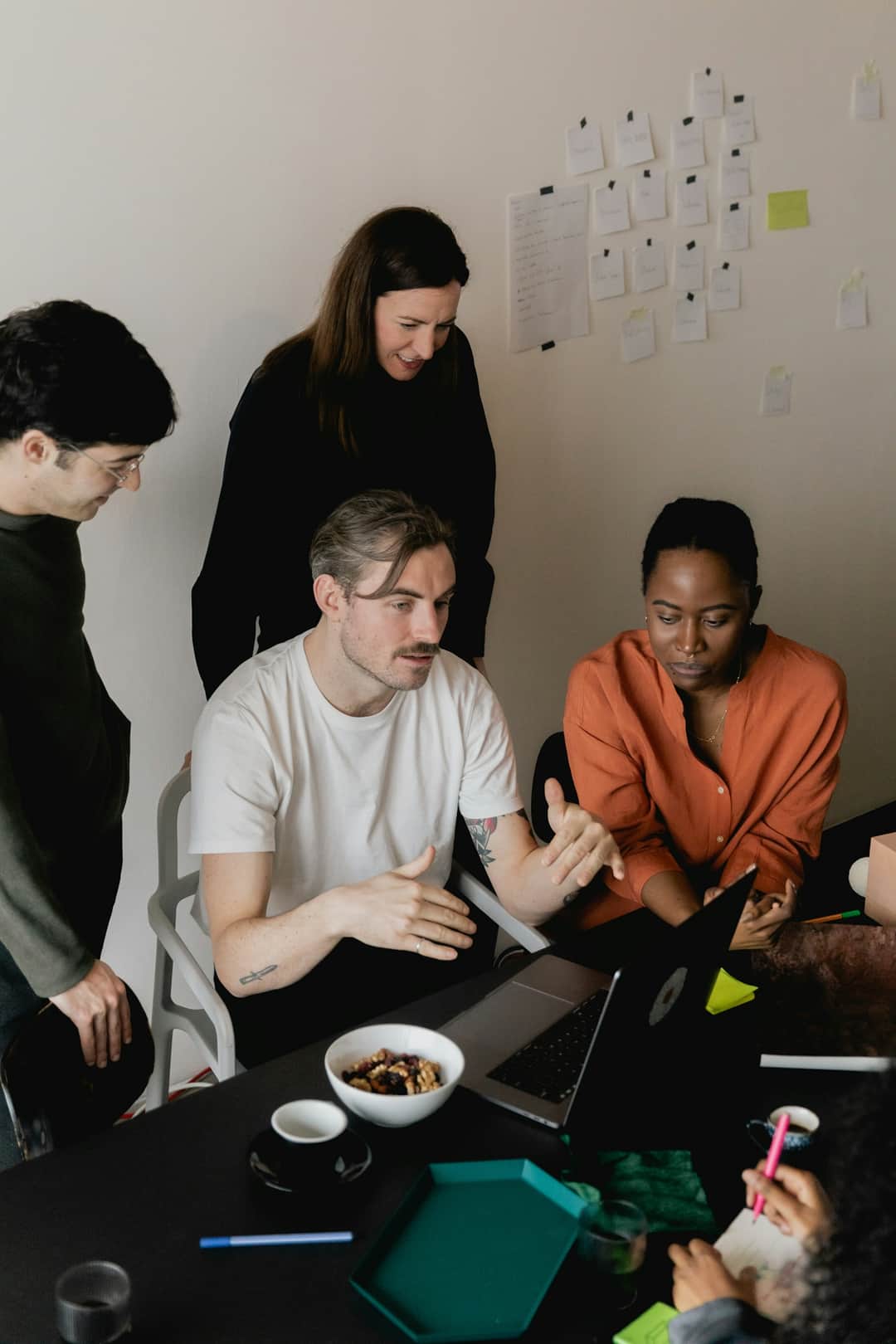 Marketing team collaborating on campaign strategy with design sketches on wall