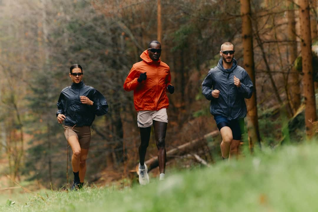 Three trail runners on a forest path illustrating an inclusive running community outdoors