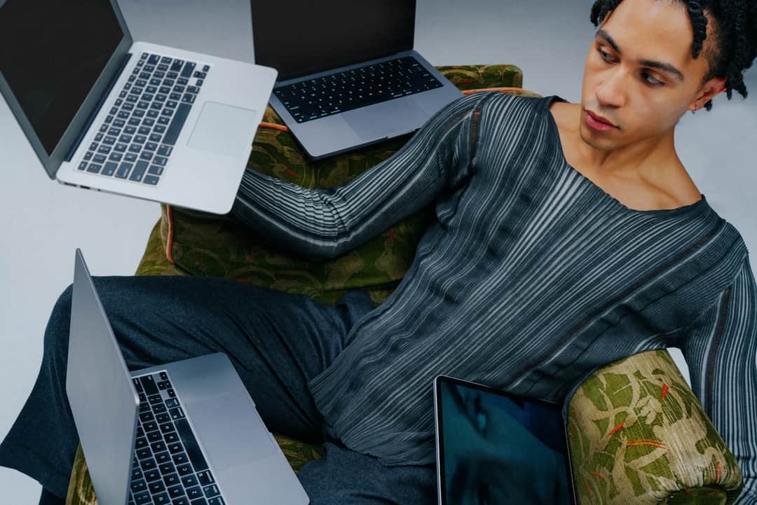 Professional strategist managing multiple laptops to segment Google Shopping Ads campaigns