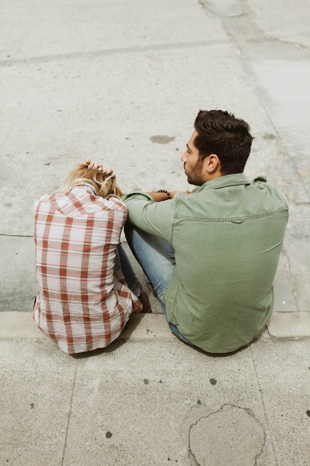 Two people seated on concrete in discussion about content outreach