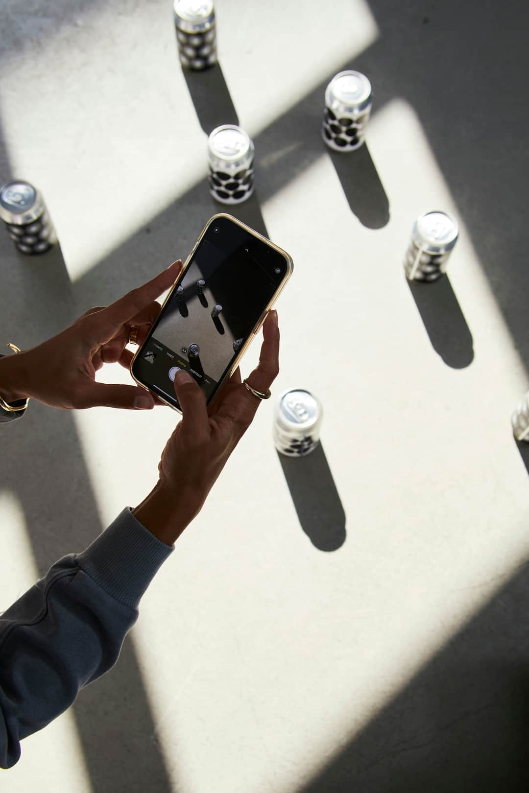 Hands with smartphone browsing cosmetic product inventory displayed on white surface