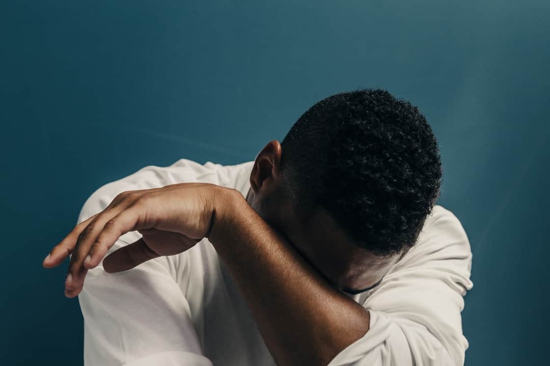 Man in white shirt listening against blue background representing voice search