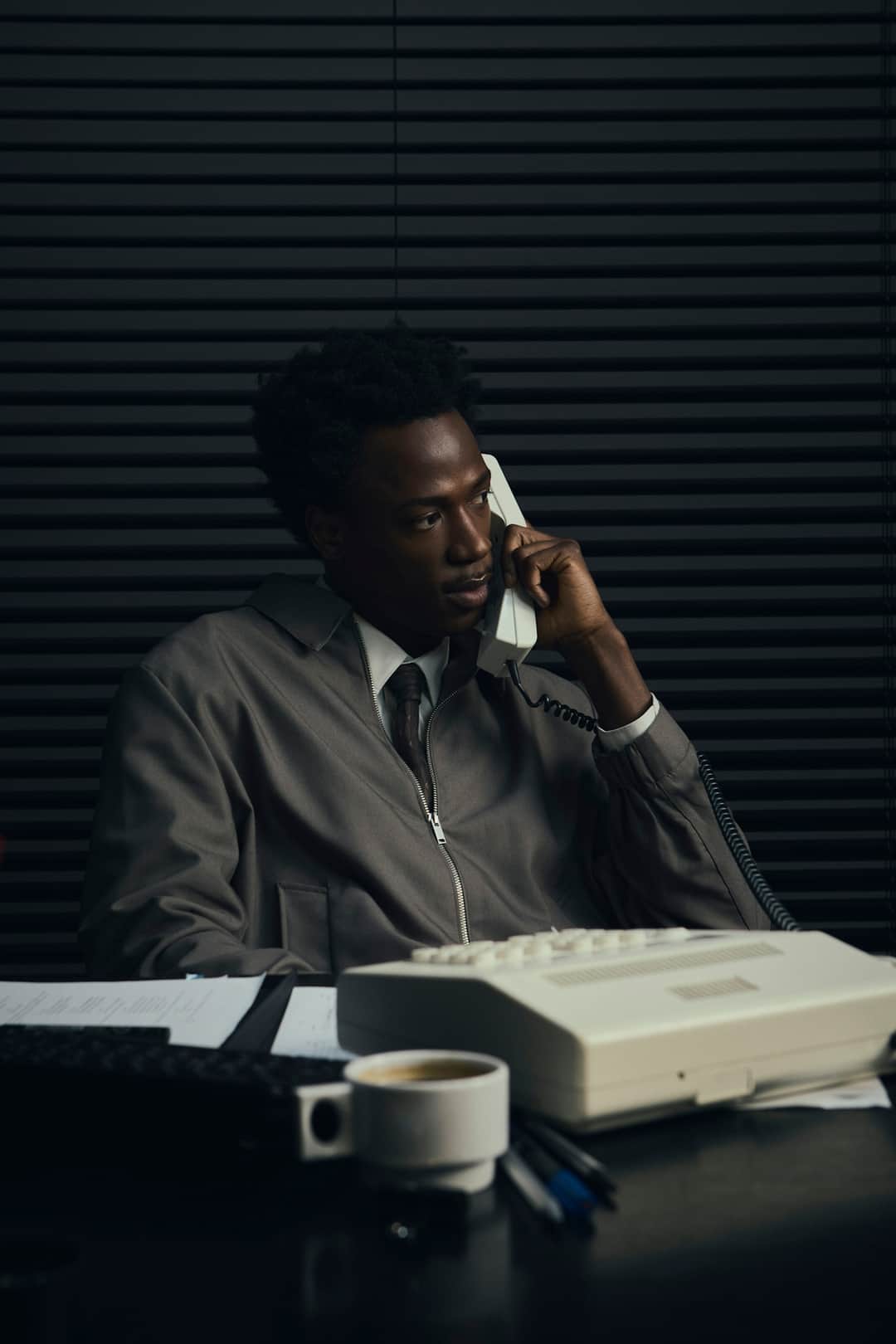 Analyst reviewing website traffic data at desk during business phone call