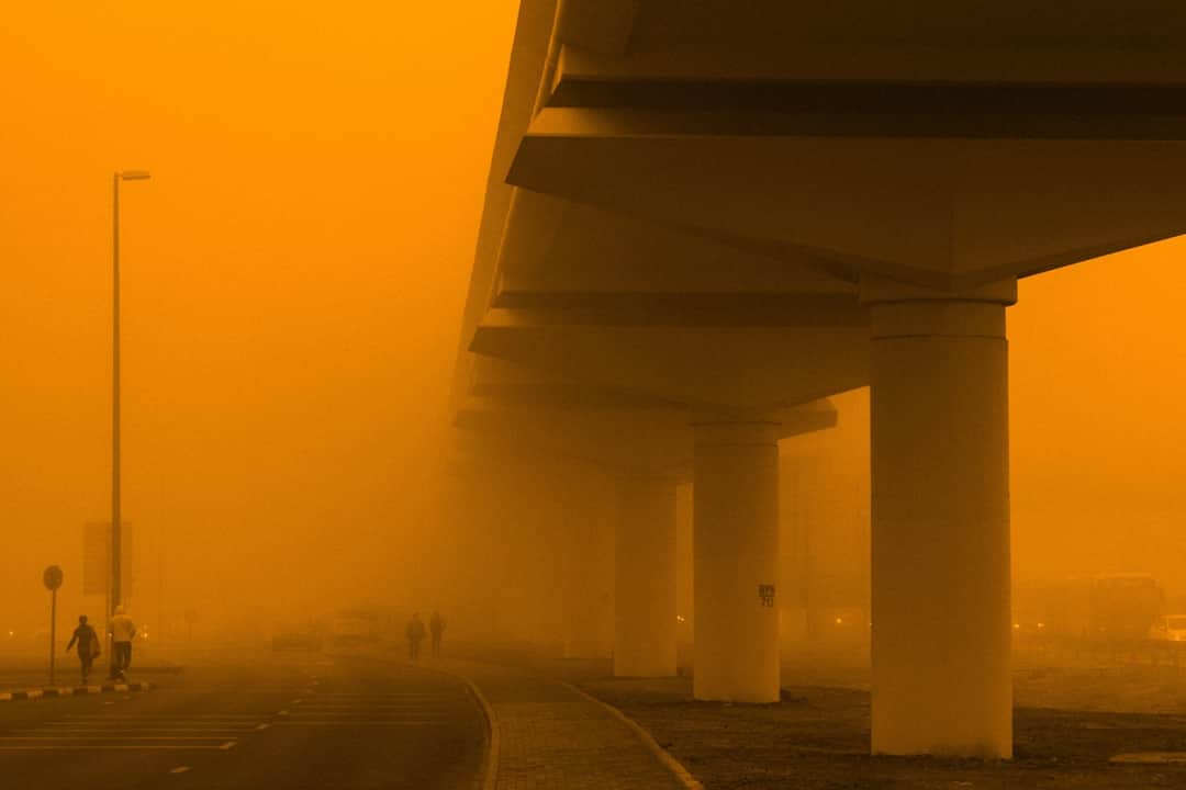 Highway underpass cloaked in dense smog illustrating the environmental impact of carbon emissions