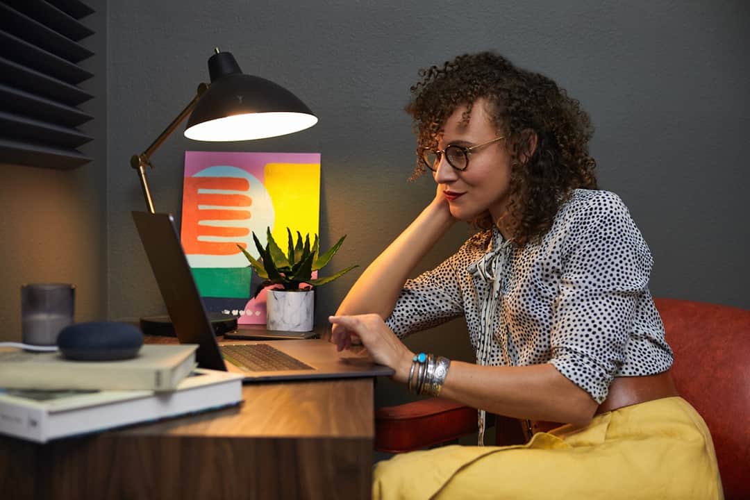 Woman at modern home office on laptop managing online visibility