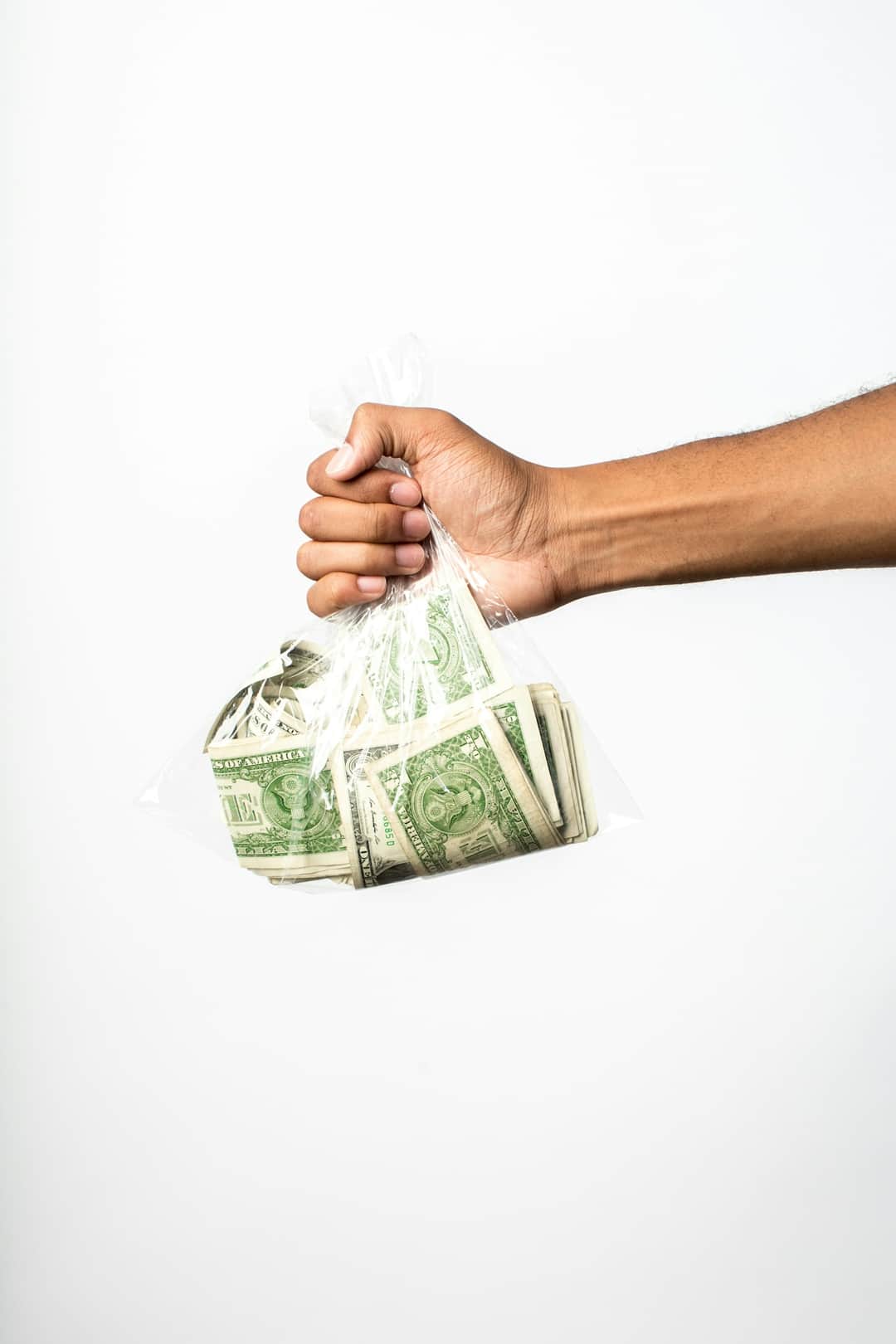 Hand holding bundle of US dollar bills wrapped with string, symbolizing grant funding