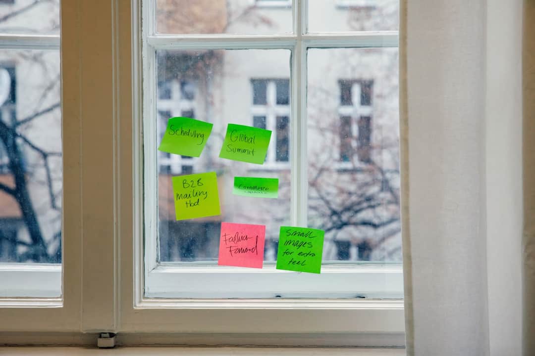 Colorful sticky notes displaying blog ideas pinned to a window during brainstorming