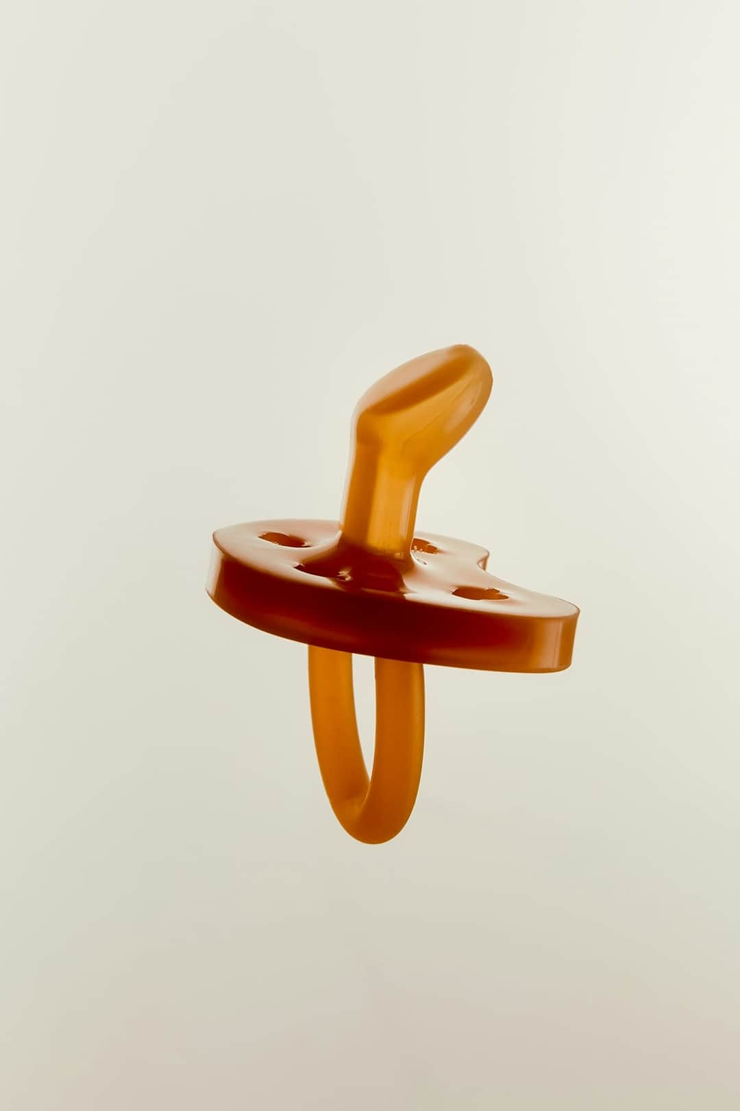 Wooden baby rattle with orange rings and natural wood handle