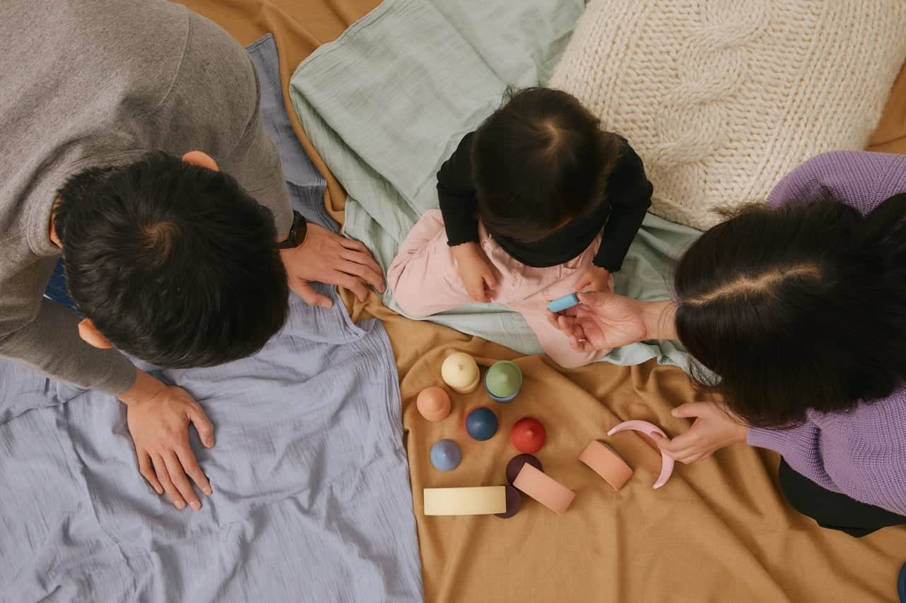 Family playing with colorful toys on blankets