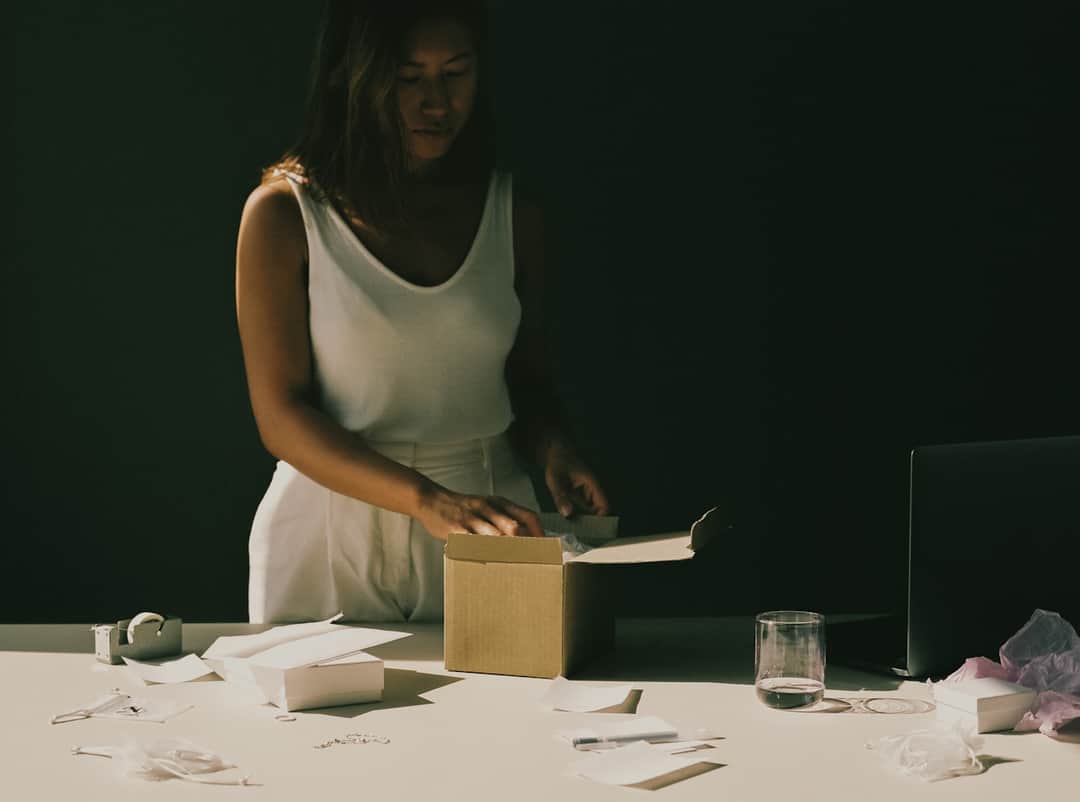 Woman unboxing e-commerce product from cardboard package
