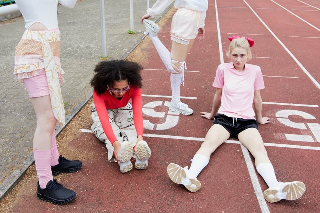 Marathon runner with medal celebrating on running track surrounded by athletes