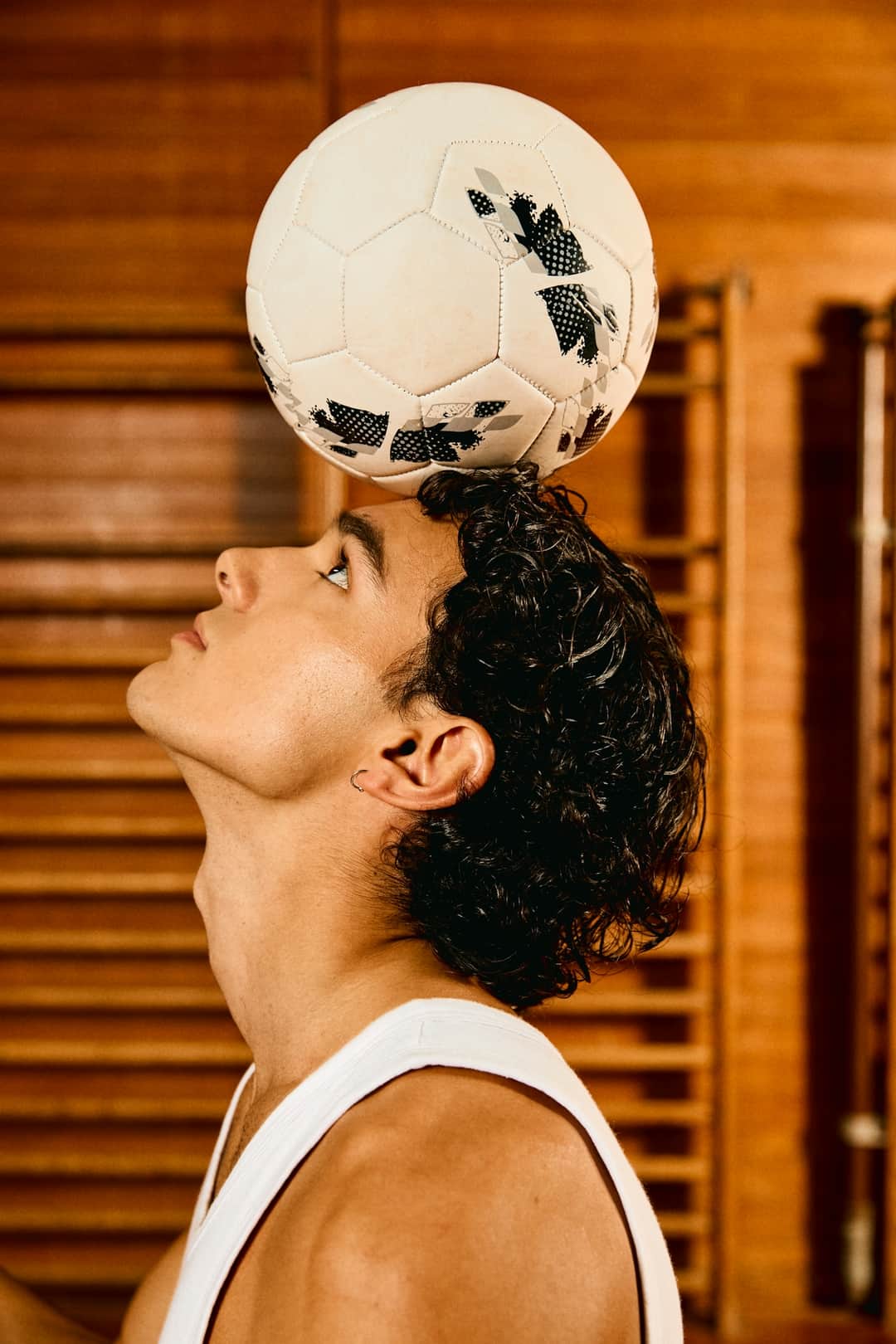 Athletic man balancing soccer ball on head