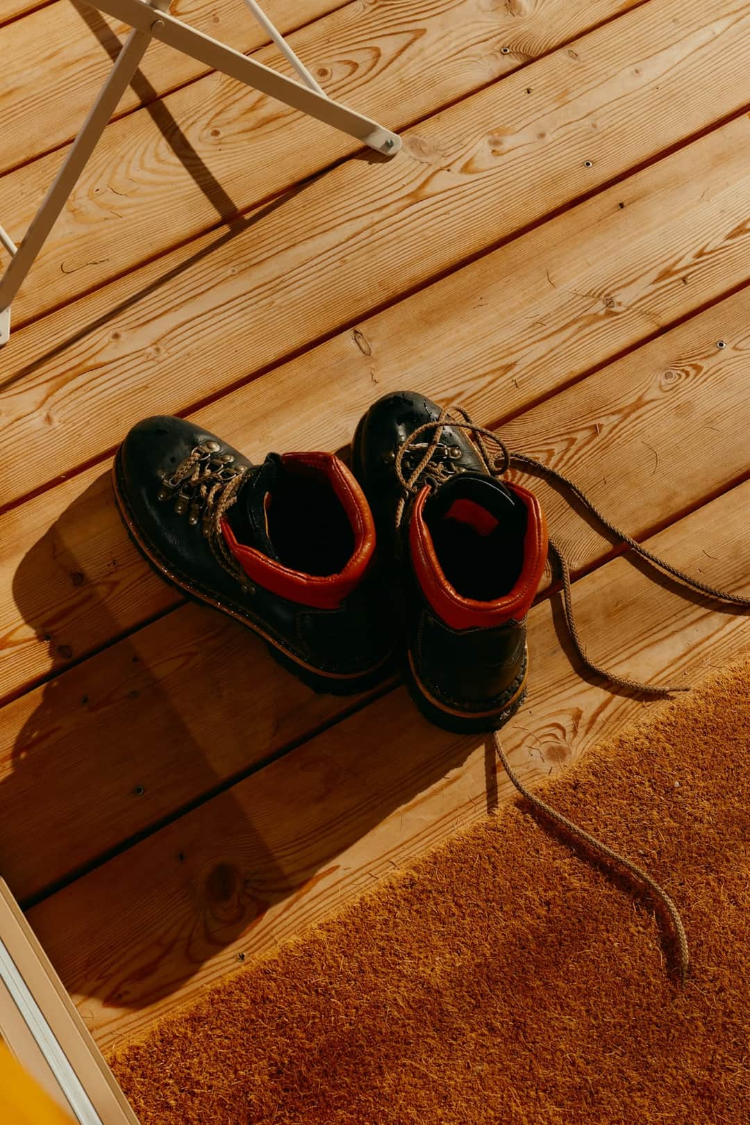Black snow boots with red lining on wooden flooring