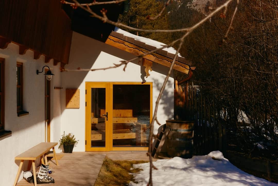 Snowy holiday cottage with golden door and ivy-covered walls