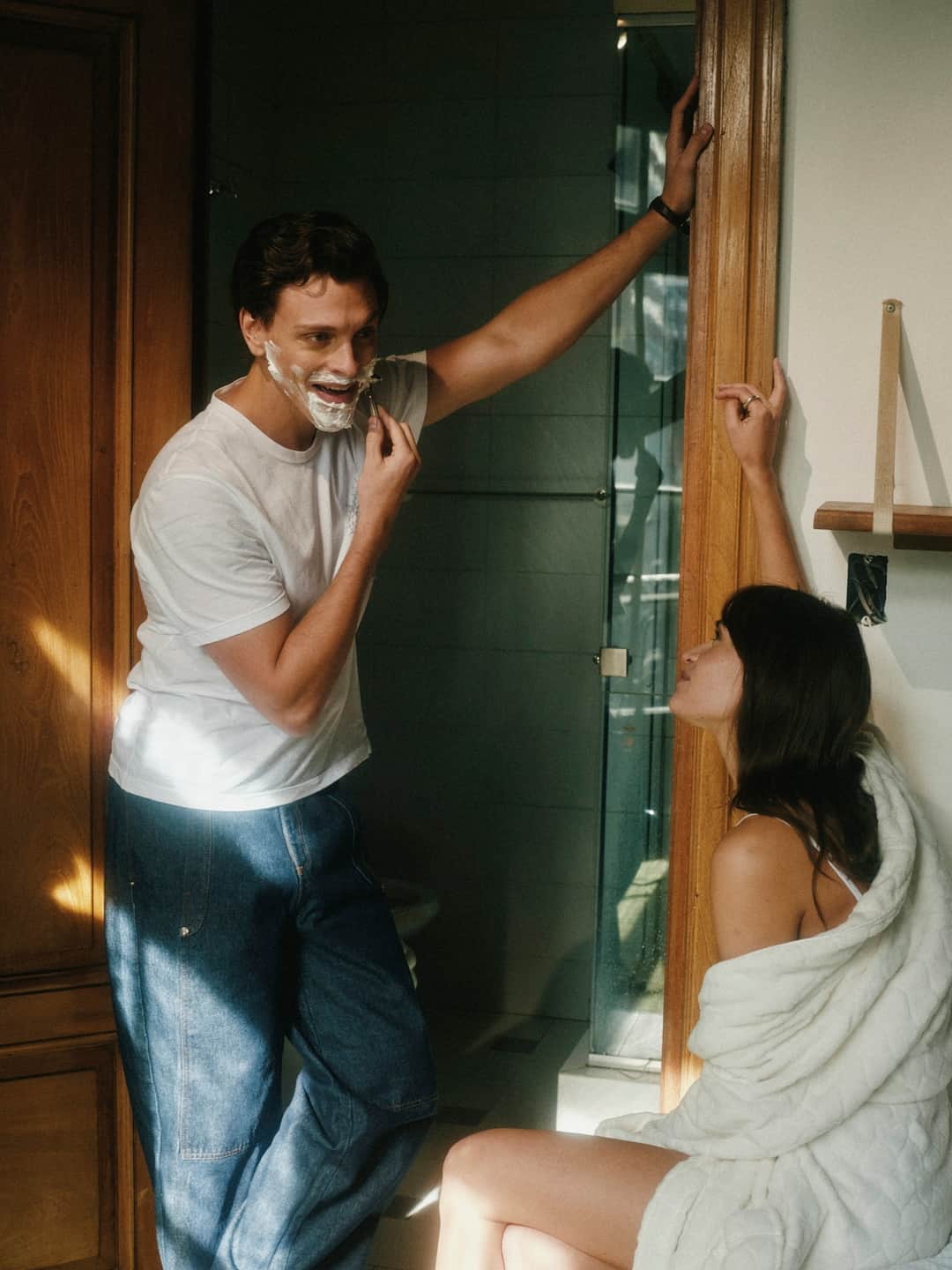 Speaker and participant discussing grooming brand building in modern bathroom setting