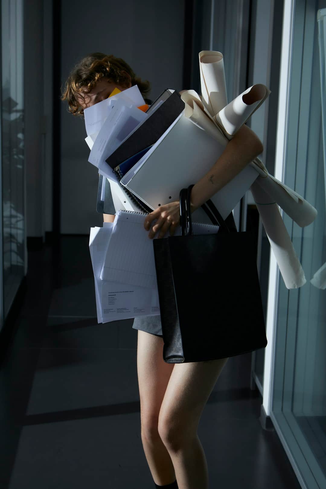 Woman holding stacked rolled papers and documents for campaign planning and project management