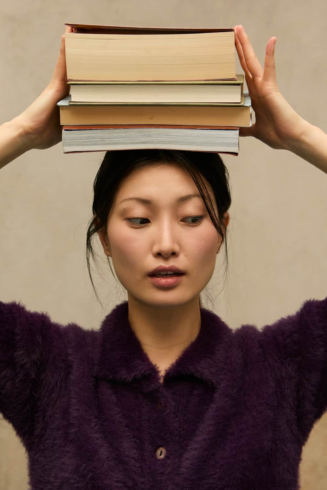 Woman with stacked books on head conceptualizing guide content strategy
