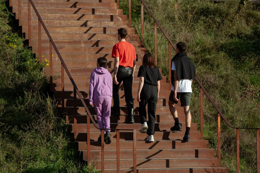 People ascending wooden stairs outdoors representing progress in alternative search