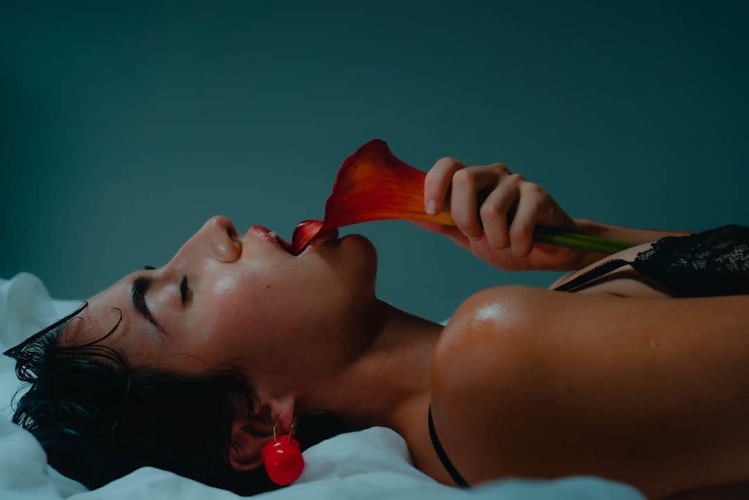 Woman with red rose and sexual wellness jelly product on turquoise background