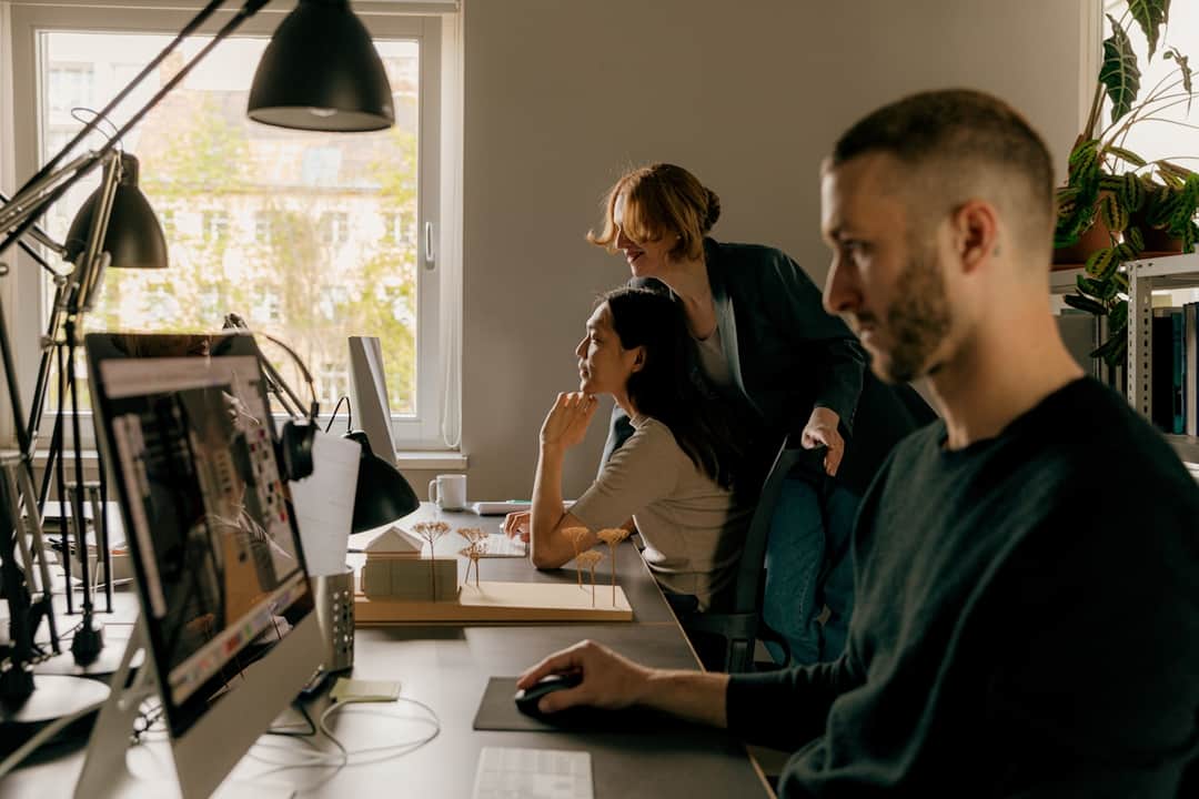 Marketing team analyzing ad tracking metrics on monitor in agency studio
