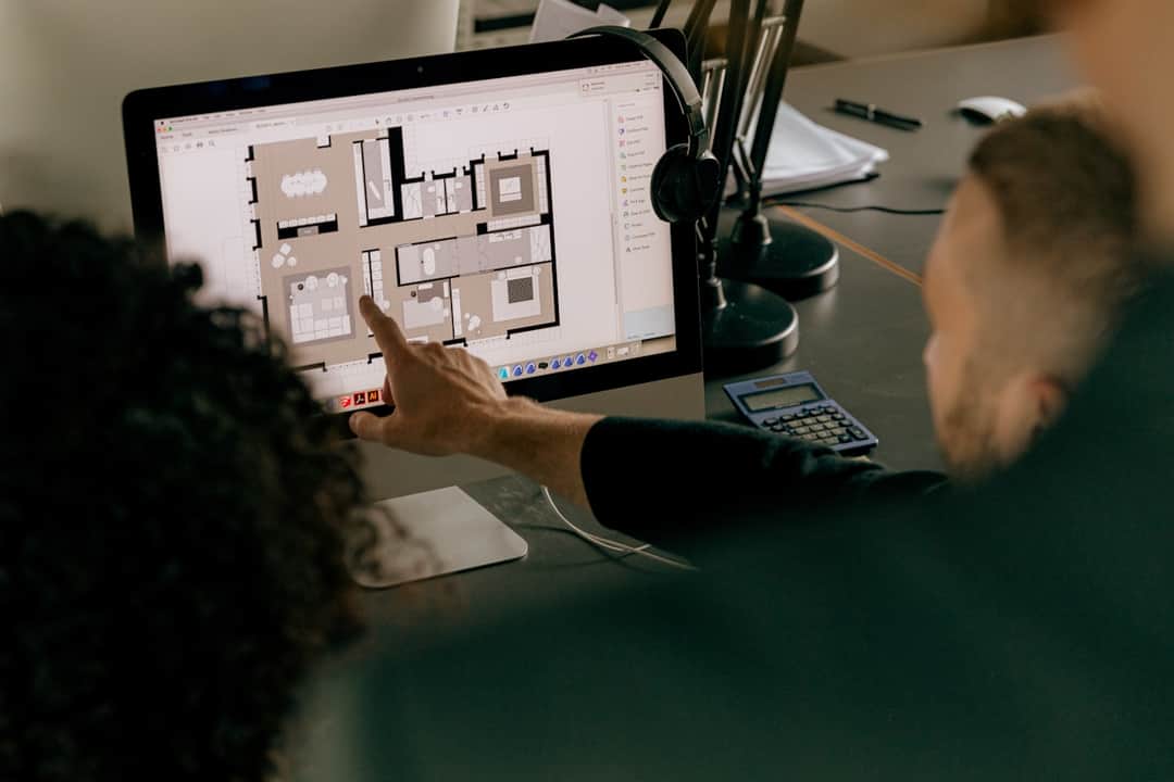 Professional analyzing structured architectural design layouts on studio monitor