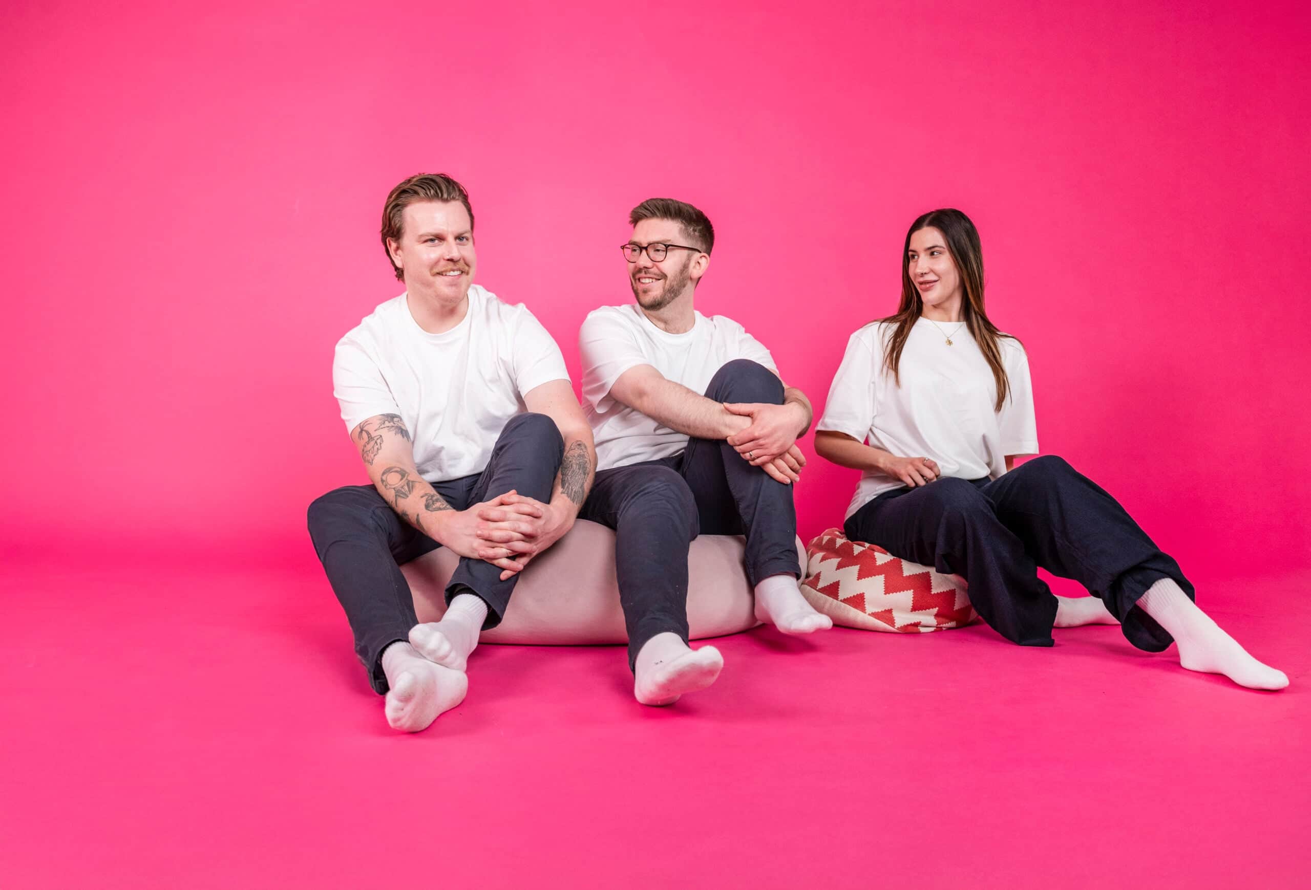 Salience e-commerce team seated on bright pink background