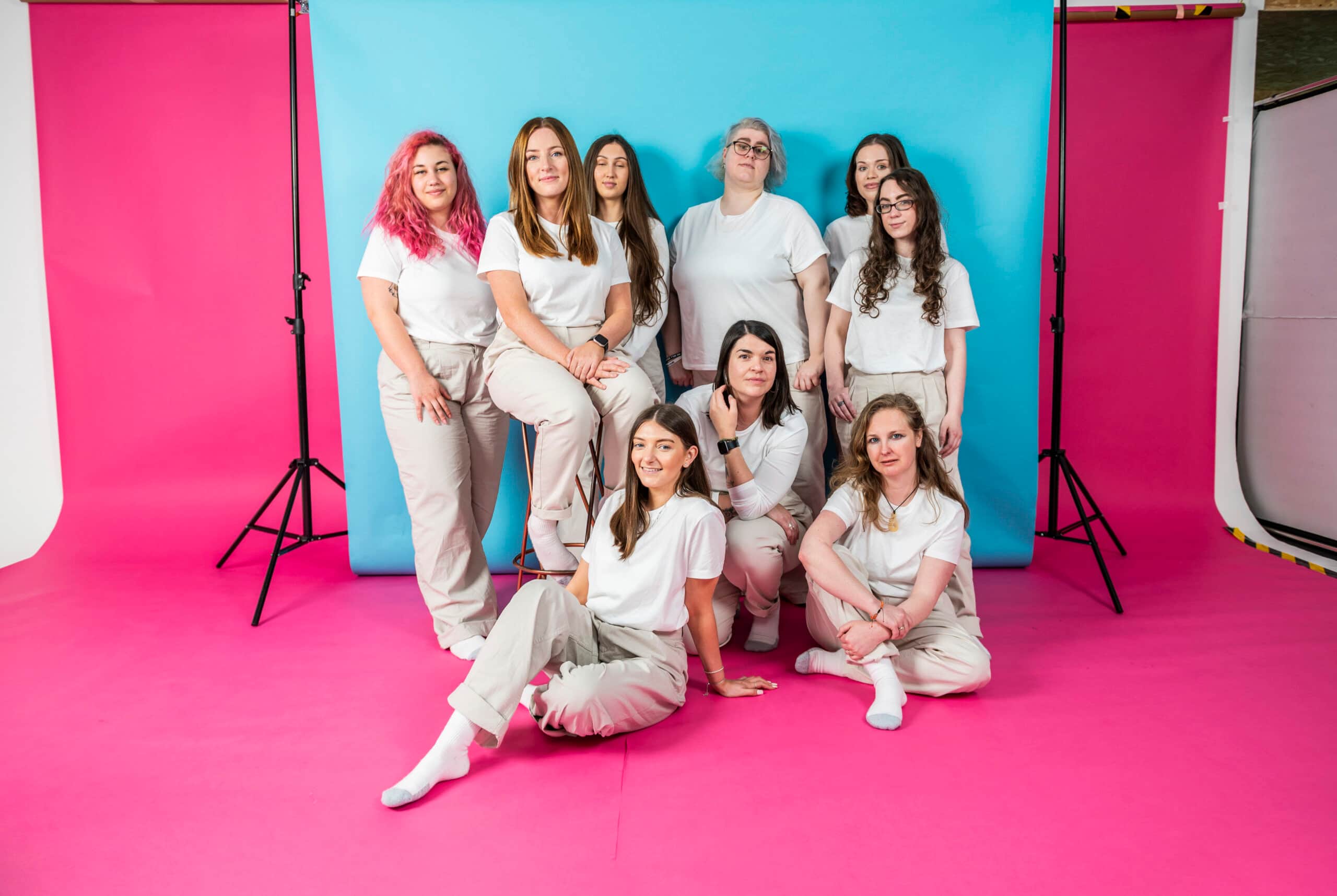 Team members posing for Salience marketing agency's "About Us" section on vibrant pink and blue background.