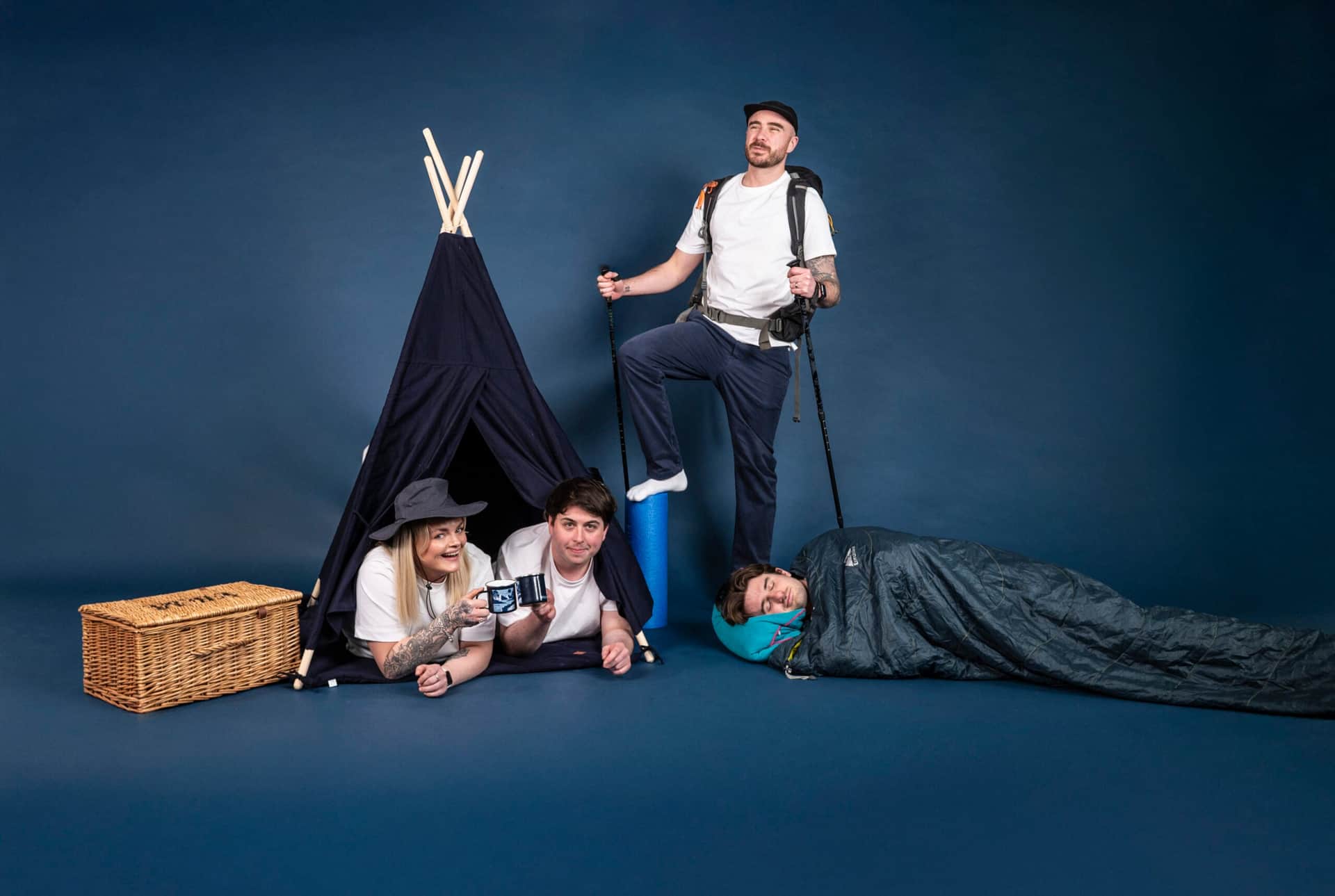 Team members camping indoors with tent, backpack, and sleeping bag, illustrating a creative team approach at Salience.