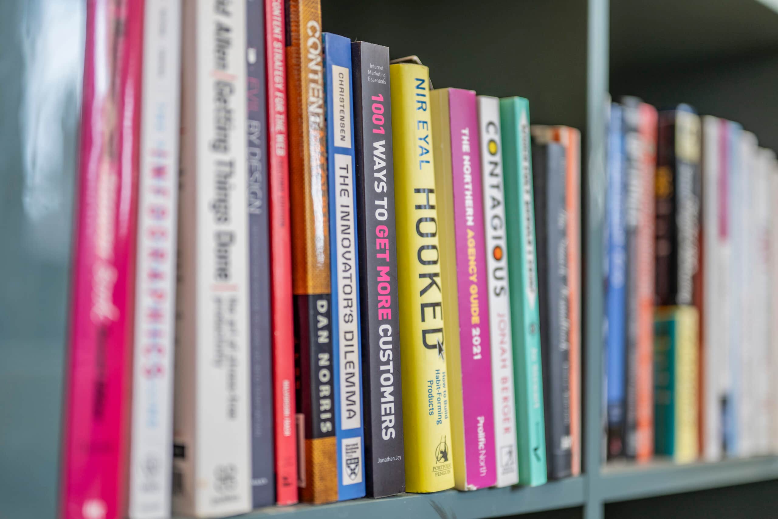 Bookshelf with marketing and business strategy books, including "Hooked" and "Contagious," reflecting Salience's expertise.