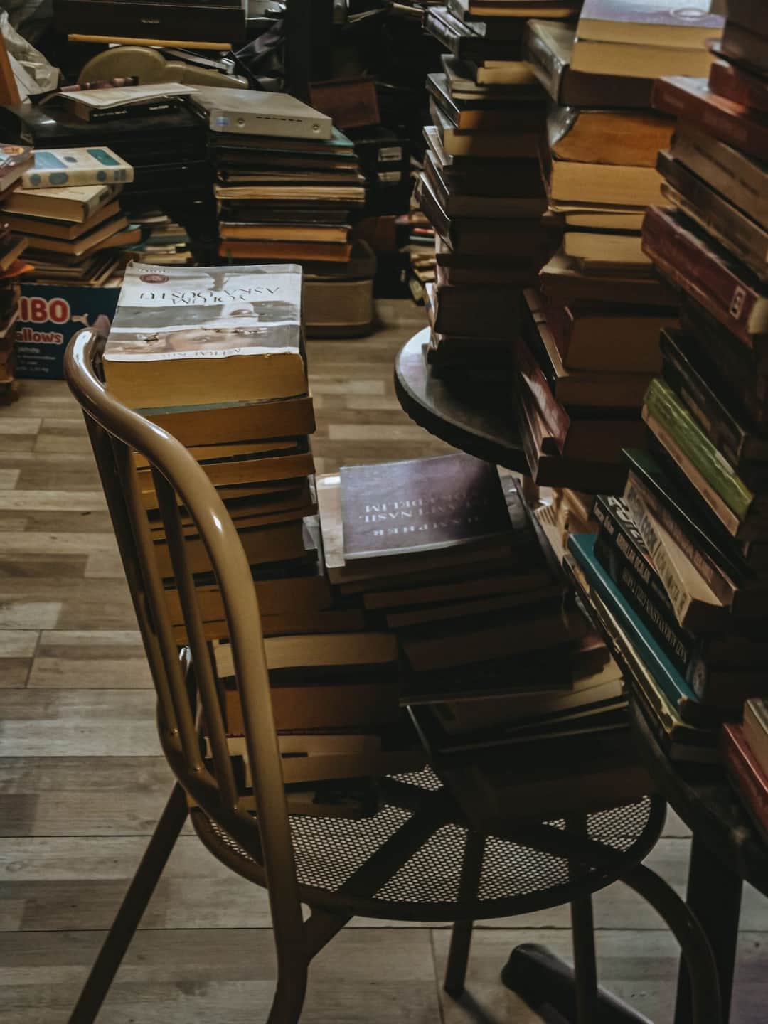 A cluttered yet charming secondhand book store filled with piles of used books. (Photo: Esra Nur Kalay via Pexels)