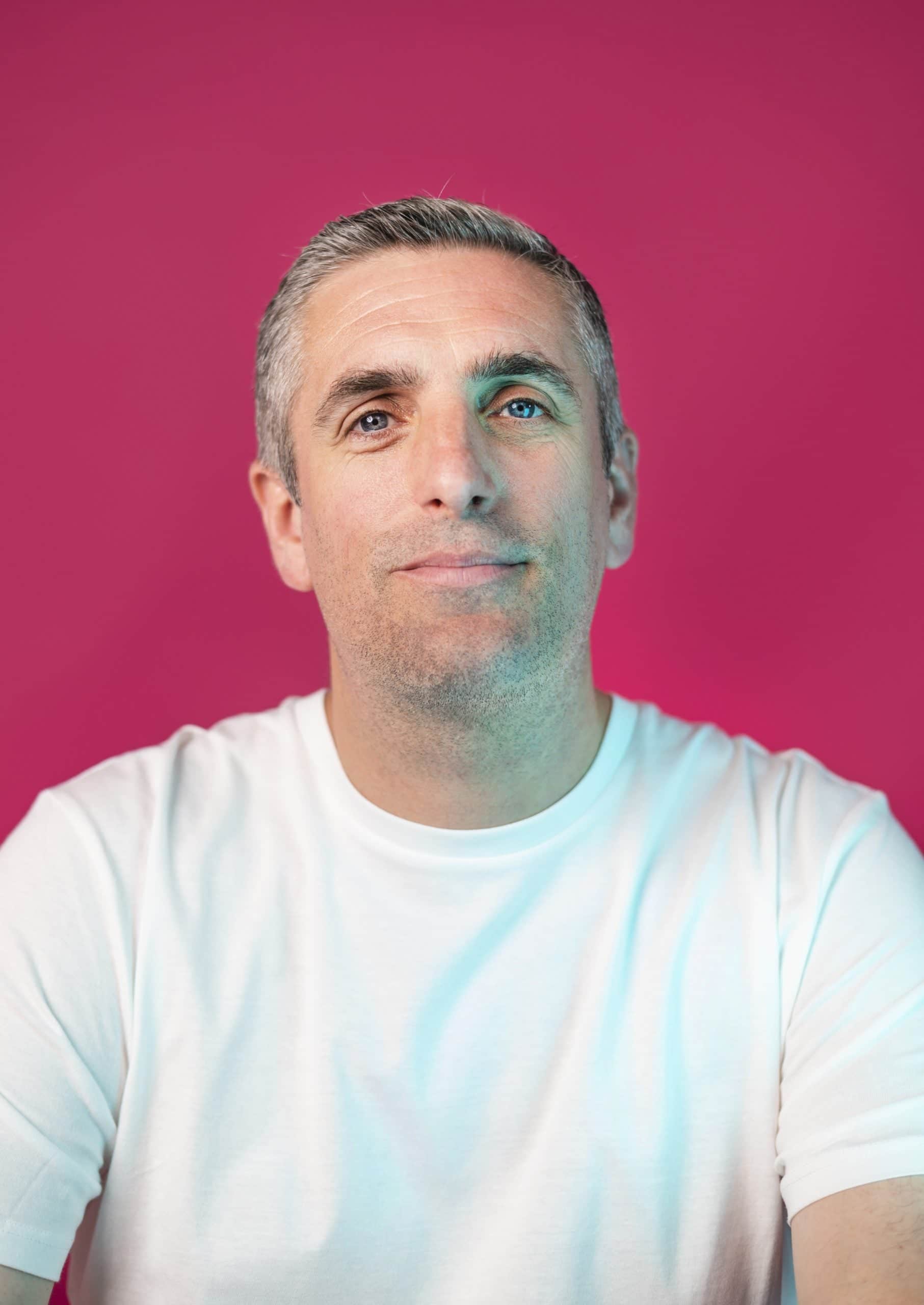 Man in white t-shirt against pink background, Salience marketing page.