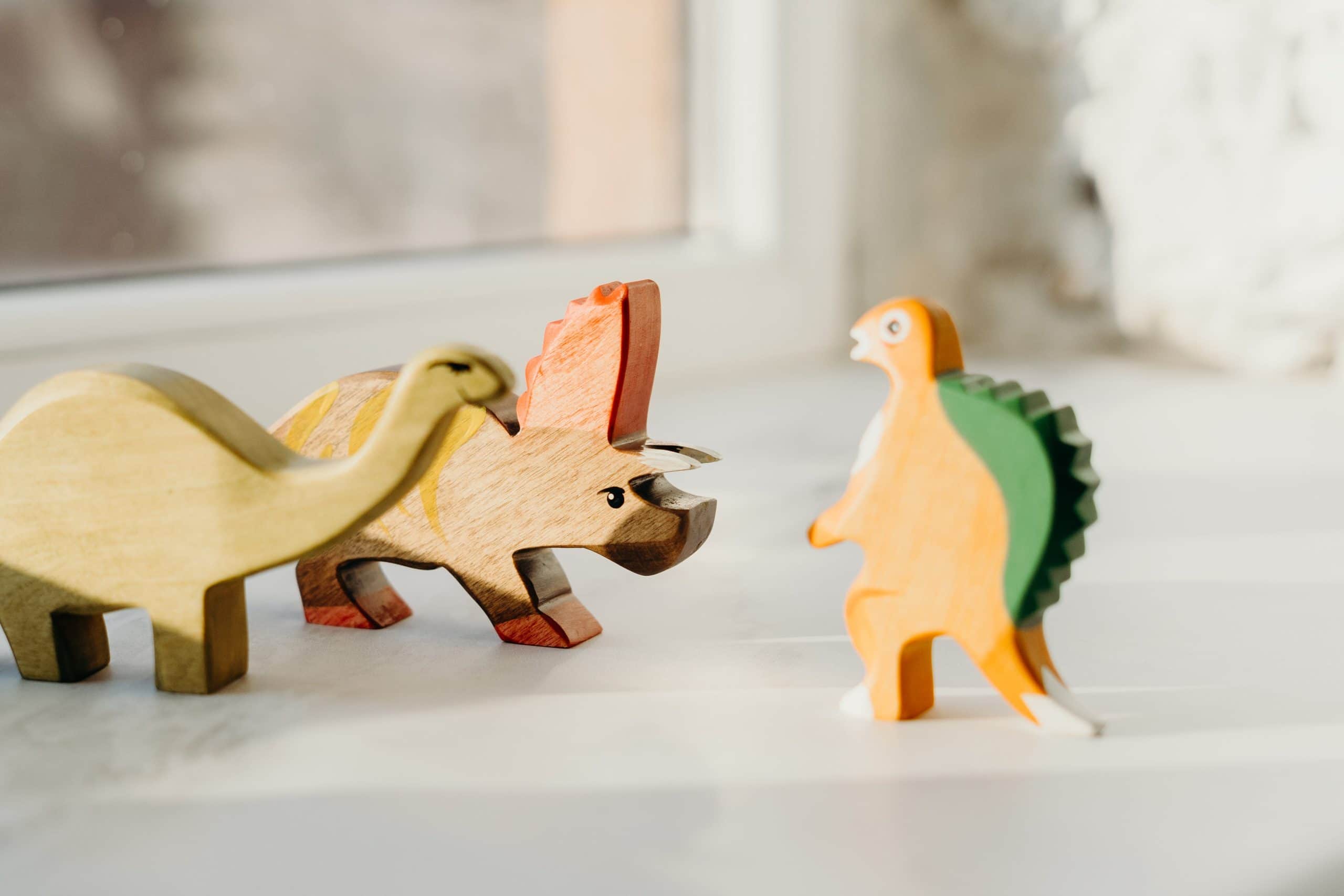 Handcrafted wooden dinosaur toys in varied bright colors