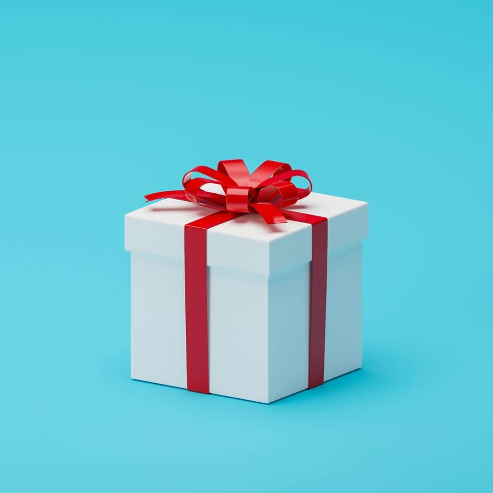 Gift box with red ribbon on blue background, ideal for marketing promotions.