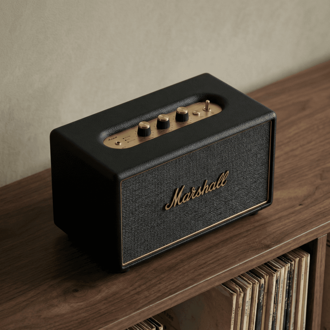Marshall Bluetooth speaker with gold controls on a wooden shelf near vinyl records
