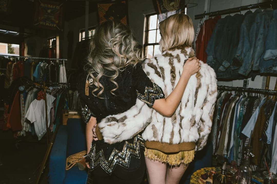 Woman examining white striped clothing in Passenger store with vintage racks