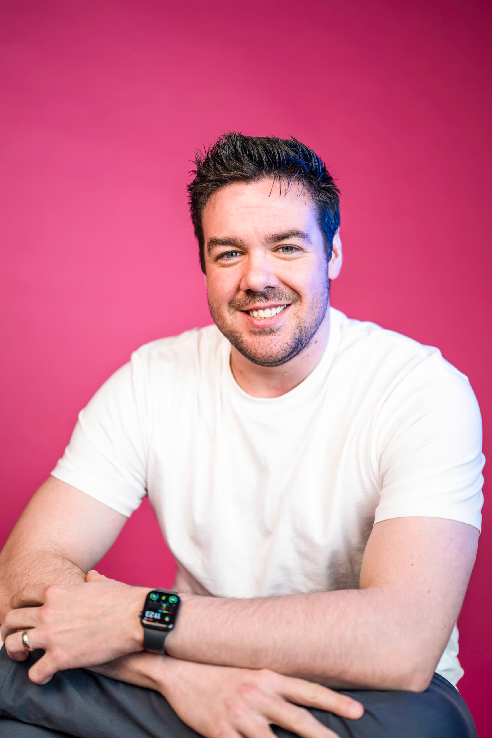 Marketing professional headshot smiling against vibrant pink background