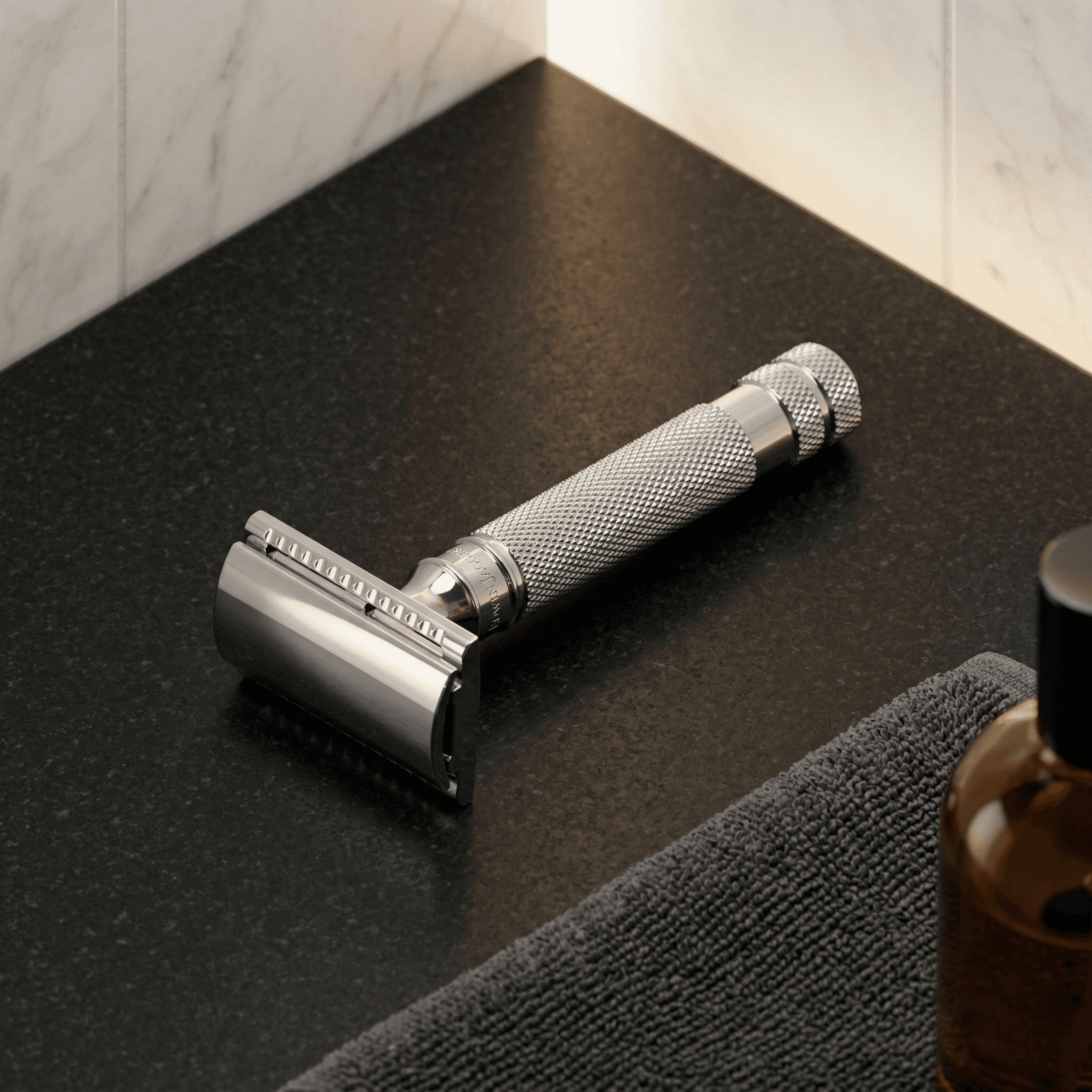 Safety razor with chrome finish and textured grip on black grooming mat