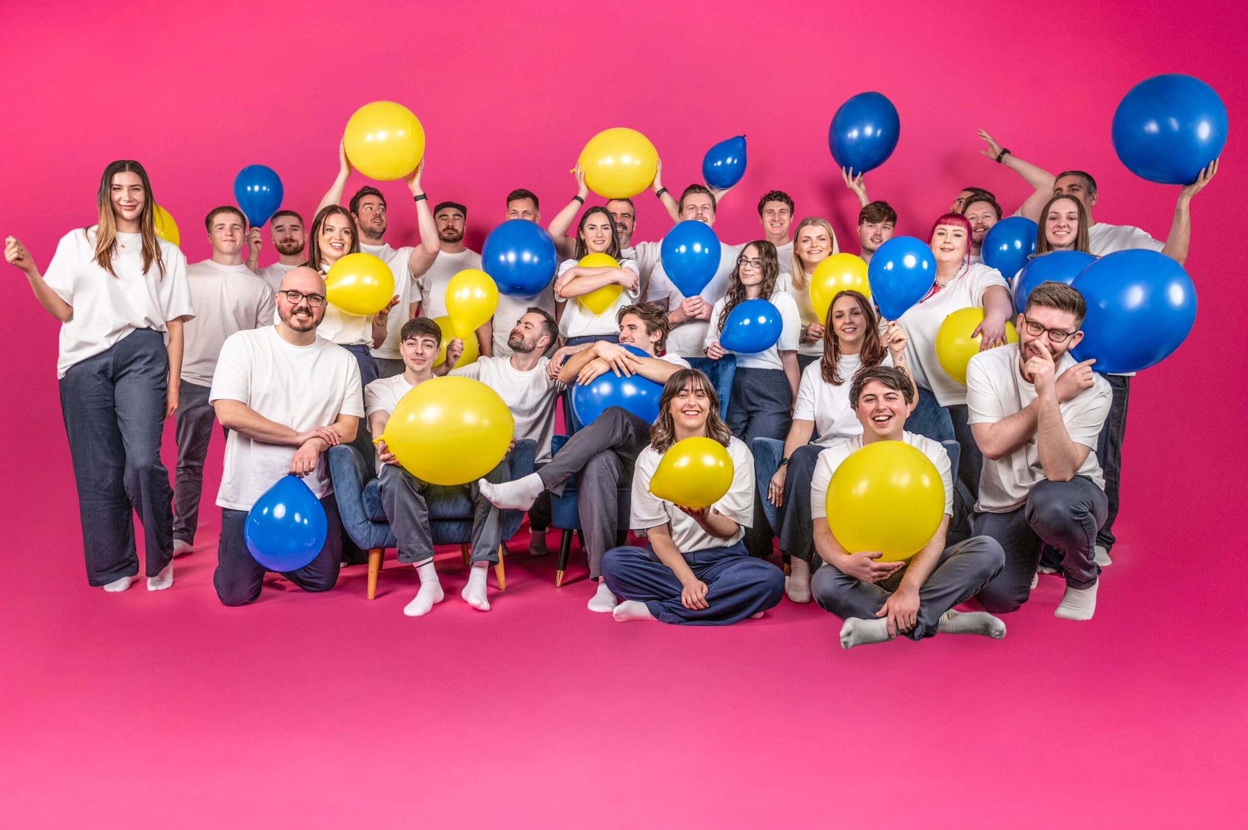 Salience e-commerce team with blue and yellow balloons on pink background