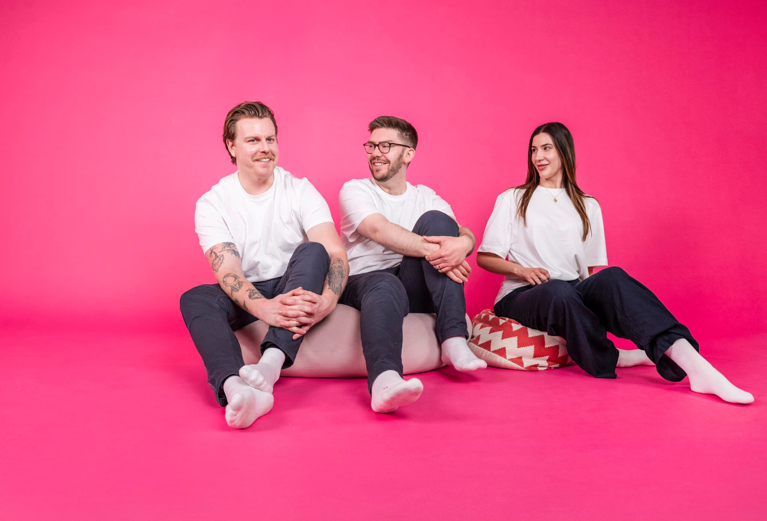 Salience e-commerce team seated on bright pink background