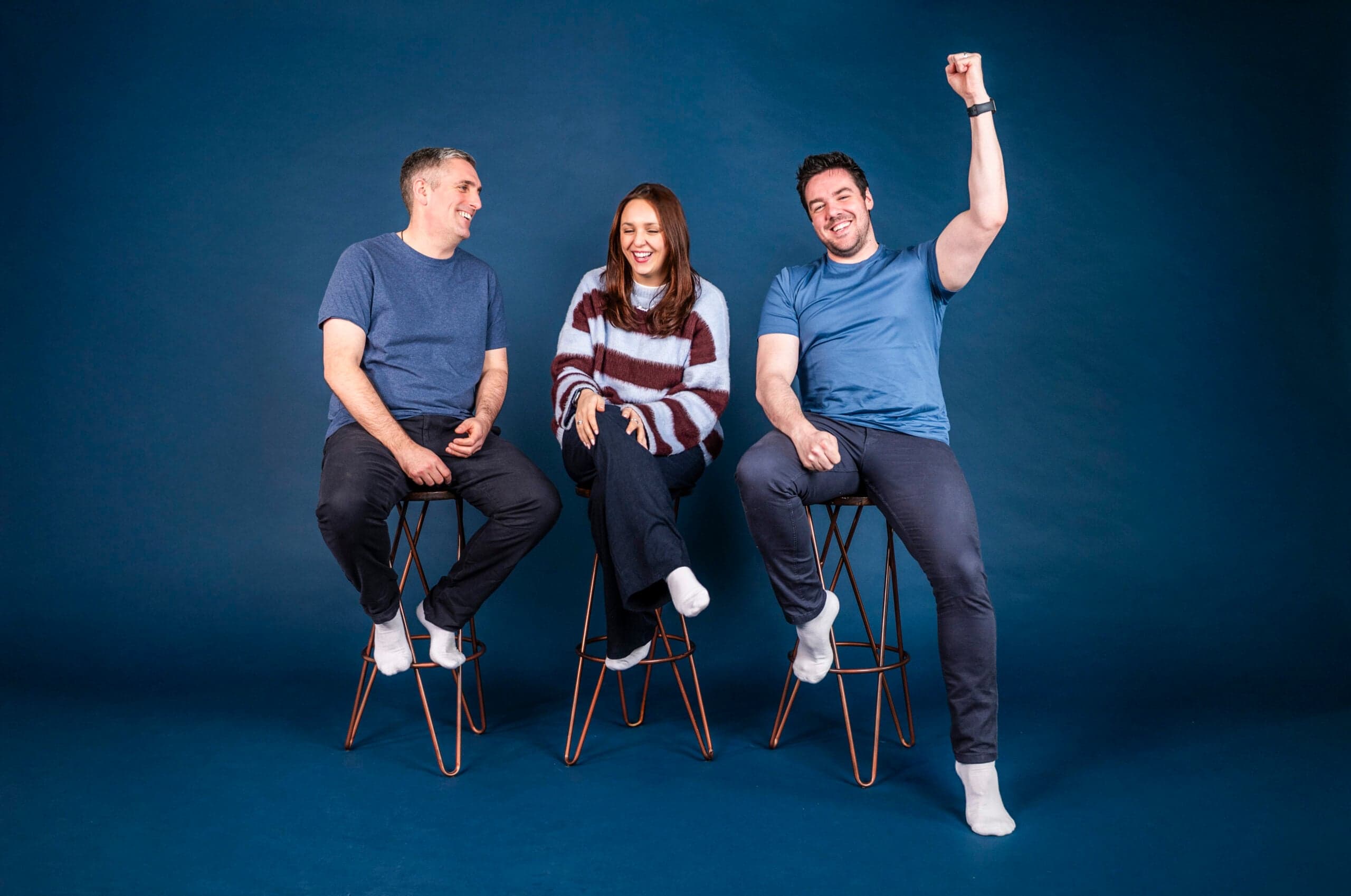 E-commerce agency team celebrating with raised fist against blue background