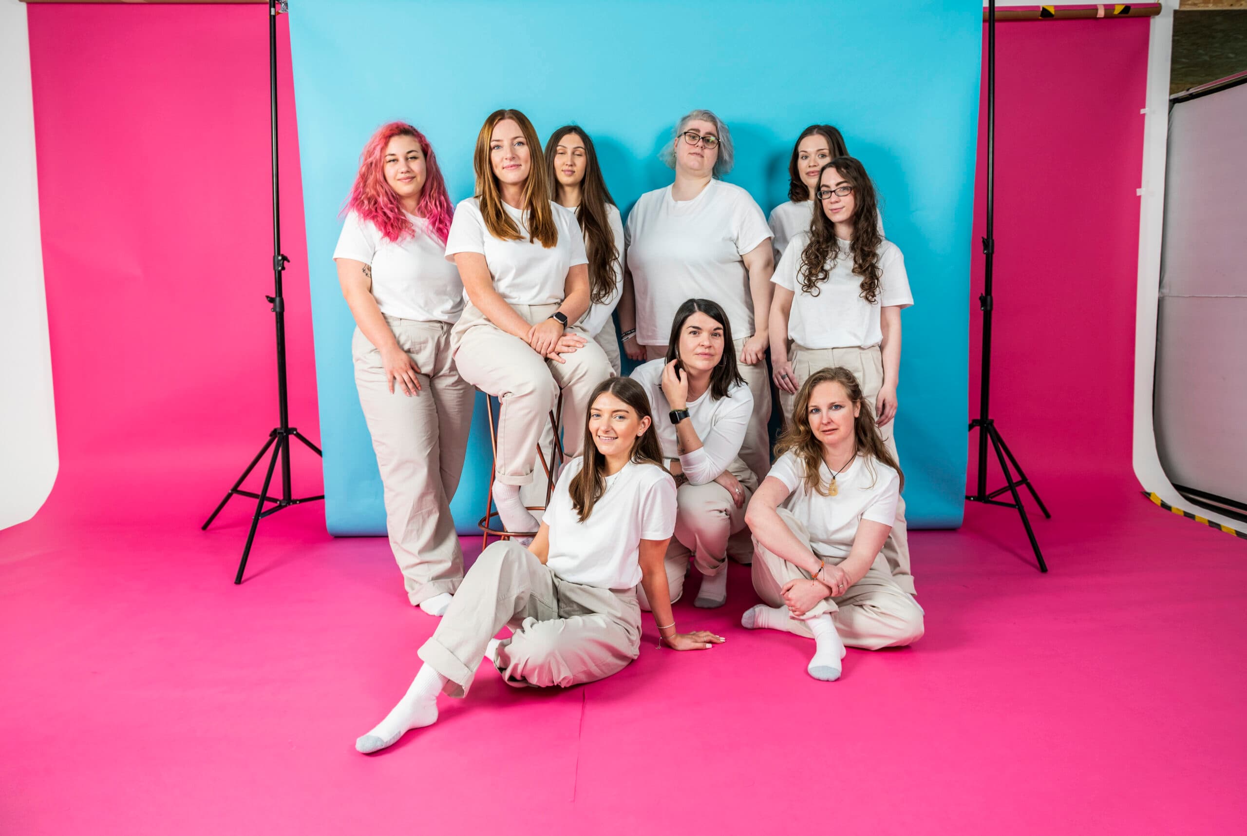 Team members posing for Salience marketing agency's "About Us" section on vibrant pink and blue background.