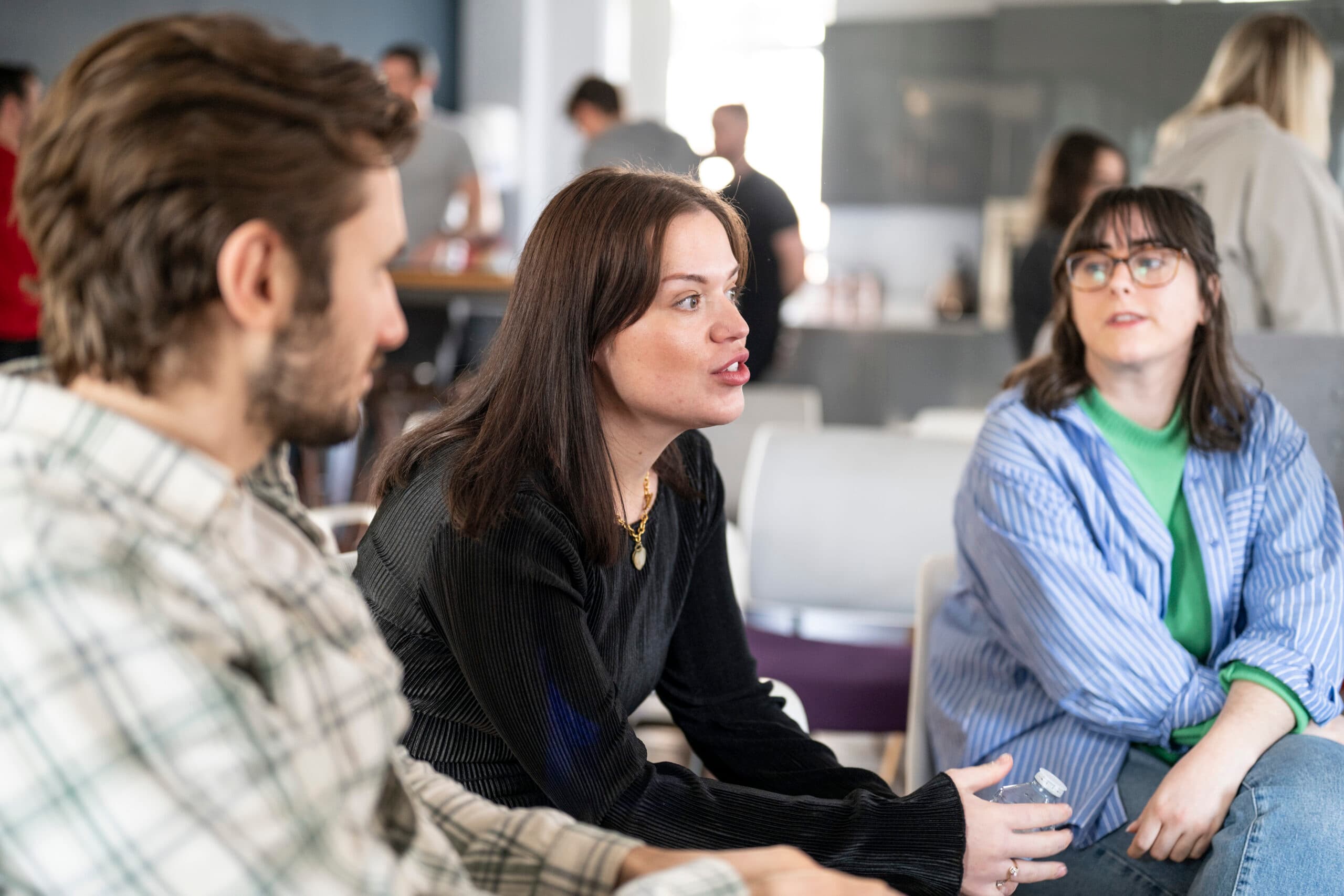 Team meeting at Salience office, three colleagues engaged in conversation, highlighting collaborative work environment.